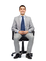 Image showing happy businessman  sitting in office chair