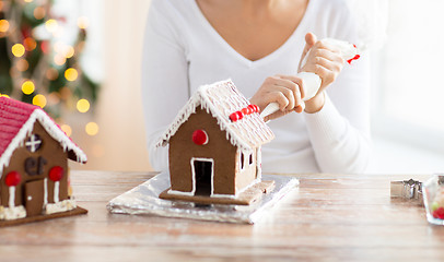 Image showing close up of woman making gingerbread houses