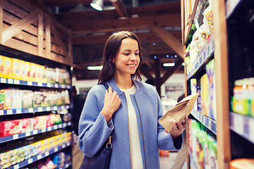 Image showing happy woman choosing and buying food in market