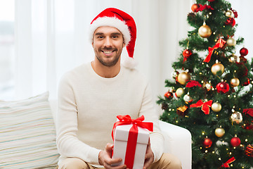 Image showing happy man with christmas gift box at home