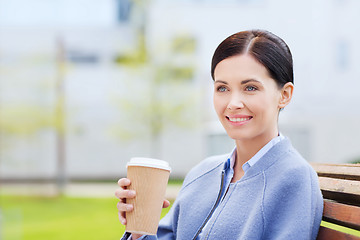 Image showing smiling woman drinking coffee outdoors