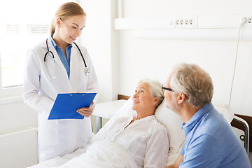 Image showing senior woman and doctor with clipboard at hospital