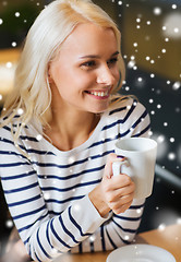 Image showing happy young woman drinking tea or coffee