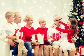 Image showing smiling family with gifts hugging at home