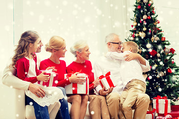 Image showing smiling family with gifts hugging at home