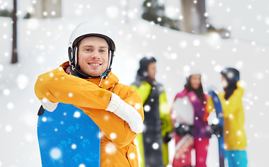 Image showing happy friends in helmets with snowboards