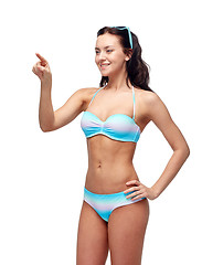 Image showing happy woman in bikini swimsuit pointing finger