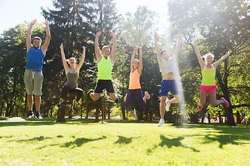 Image showing group of happy friends jumping high outdoors