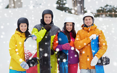 Image showing happy friends in helmets with snowboards