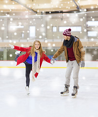 Image showing happy couple holding hands on skating rink