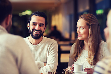 Image showing happy friends meeting and drinking tea or coffee