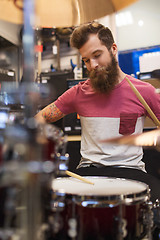 Image showing male musician playing cymbals at music store