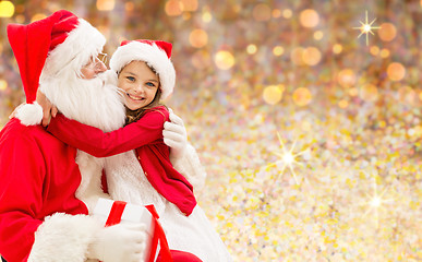 Image showing smiling girl cuddling with santa claus over lights