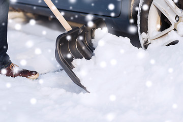 Image showing closeup of man digging snow with shovel near car