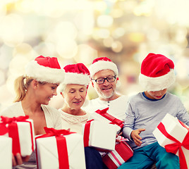 Image showing happy family in santa helper hats with gift boxes