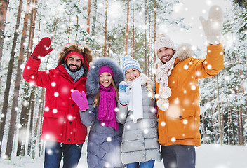 Image showing group of friends waving hands in winter forest