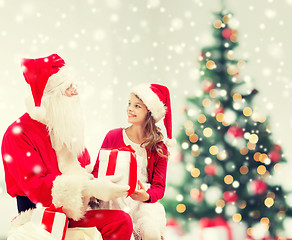 Image showing smiling little girl with santa claus and gifts