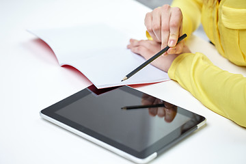 Image showing close up of woman with tablet pc and notebook