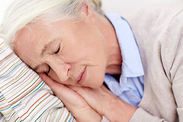 Image showing happy senior woman sleeping on pillow at home