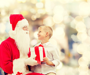 Image showing smiling little boy with santa claus and gifts