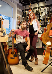 Image showing couple of musicians with guitar at music store