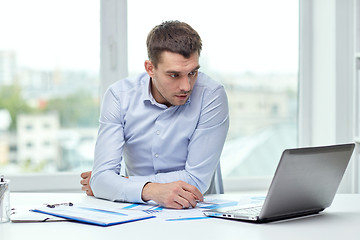 Image showing stressed businessman with laptop at office