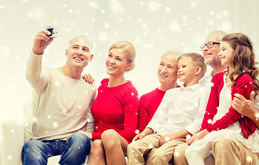 Image showing smiling family with camera at home