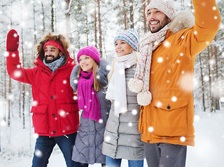 Image showing group of friends waving hands in winter forest