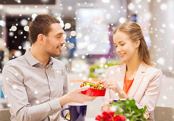 Image showing happy couple with present and flowers in mall