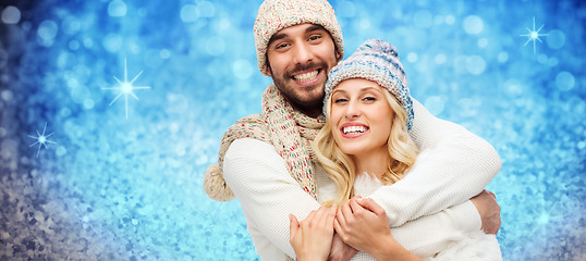 Image showing happy couple in winter clothes hugging over lights