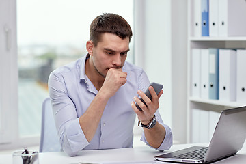 Image showing businessman with smartphone and laptop at office