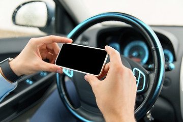 Image showing close up of man hand with smartphone driving car