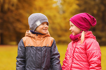 Image showing happy little girl and boy talking in autumn park