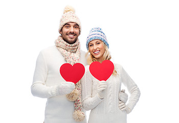 Image showing smiling couple in winter clothes with red hearts