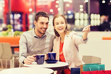 Image showing happy couple with shopping bags drinking coffee