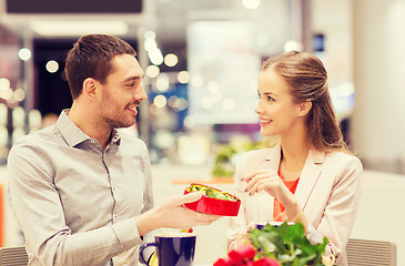 Image showing happy couple with present and flowers in mall