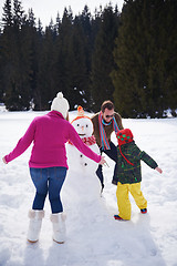 Image showing happy family building snowman