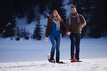 Image showing couple having fun and walking in snow shoes