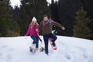 Image showing couple having fun and walking in snow shoes