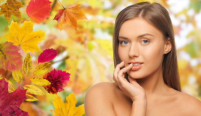 Image showing beautiful young woman face over autumn leaves