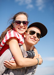 Image showing smiling teenagers in sunglasses having fun outside