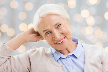 Image showing happy senior woman face over lights background