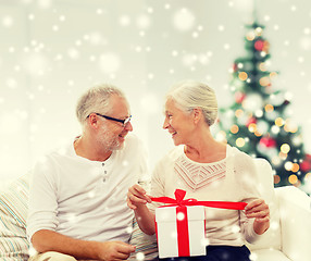 Image showing happy senior couple with gift box at home