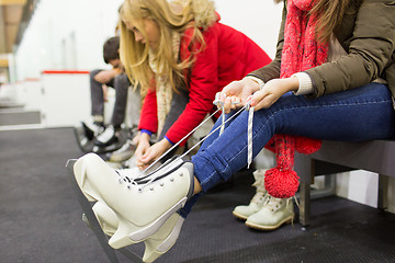 Image showing close up of woman wearing skates on skating rink