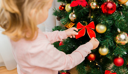 Image showing close up of little girl decorating christmas tree