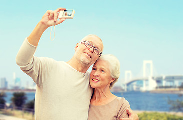 Image showing senior couple with camera over rainbow bridge
