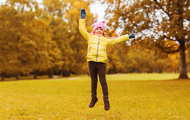 Image showing happy little girl jumping outdoors