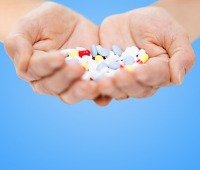 Image showing close up of senior woman hands with pills