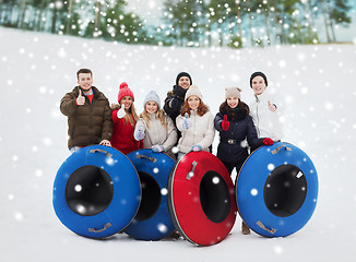 Image showing group of smiling friends with snow tubes