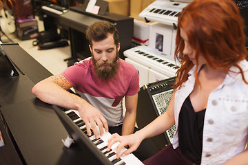 Image showing man and woman playing piano at music store